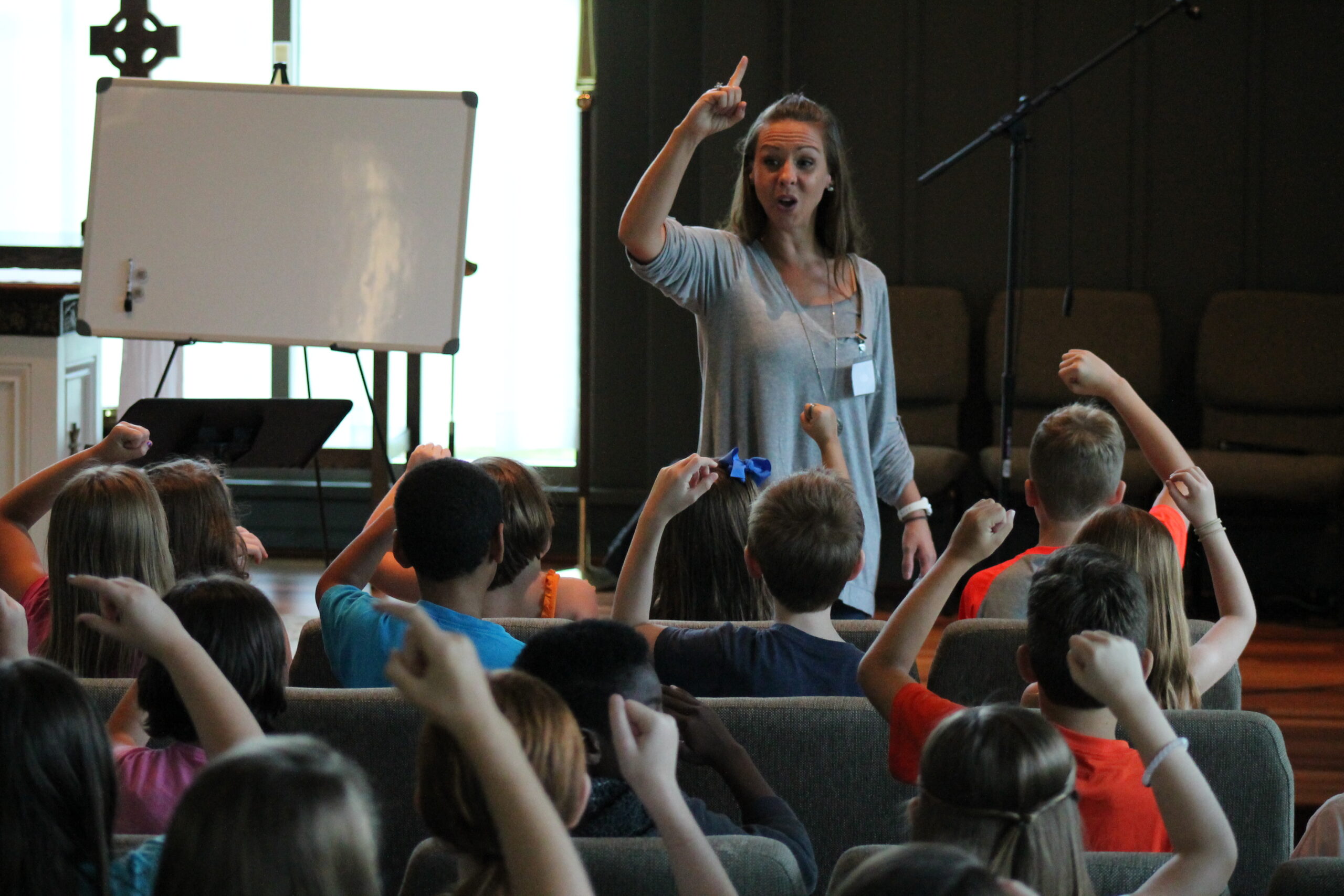 A woman speaks to an engaged audience in a seminar room.
