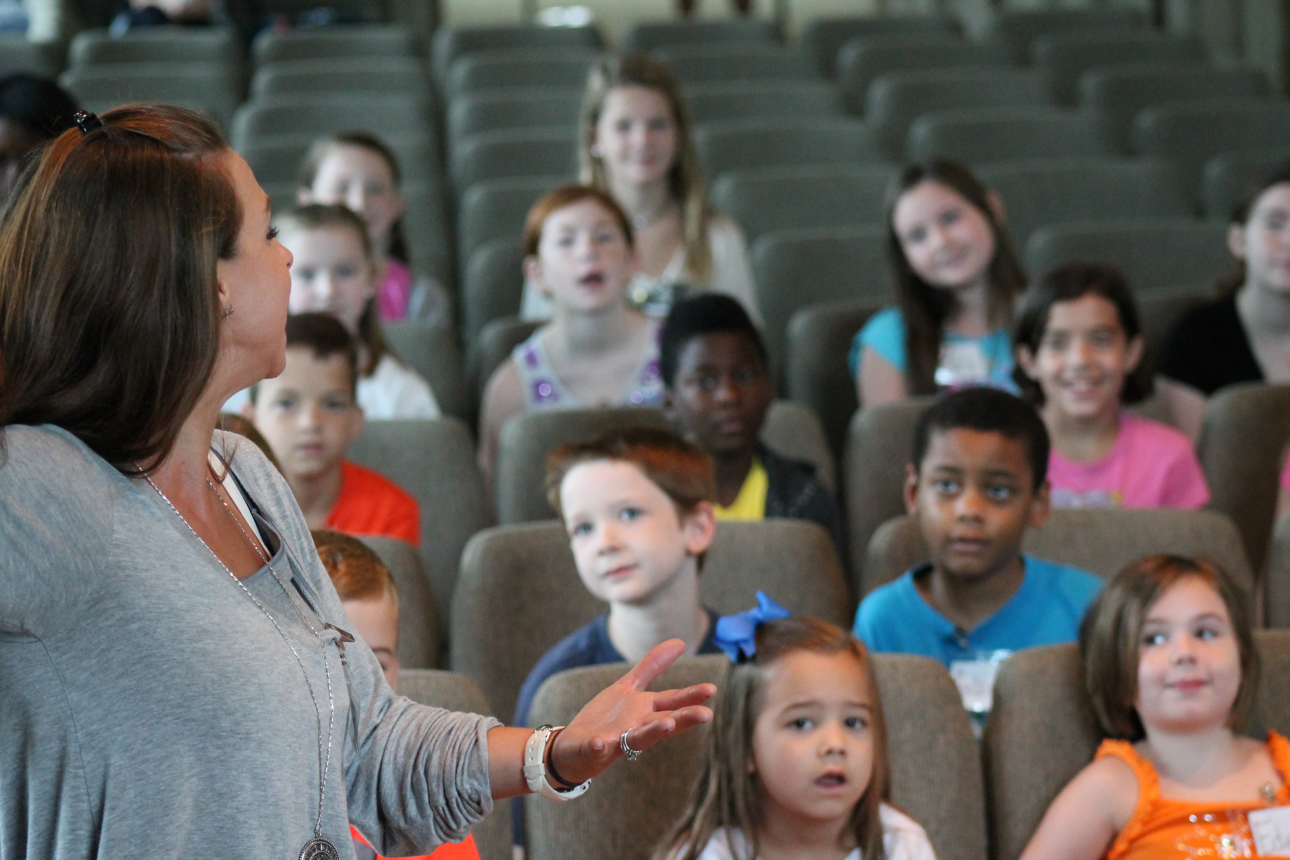 Teacher engaging a diverse group of children in a classroom discussion.