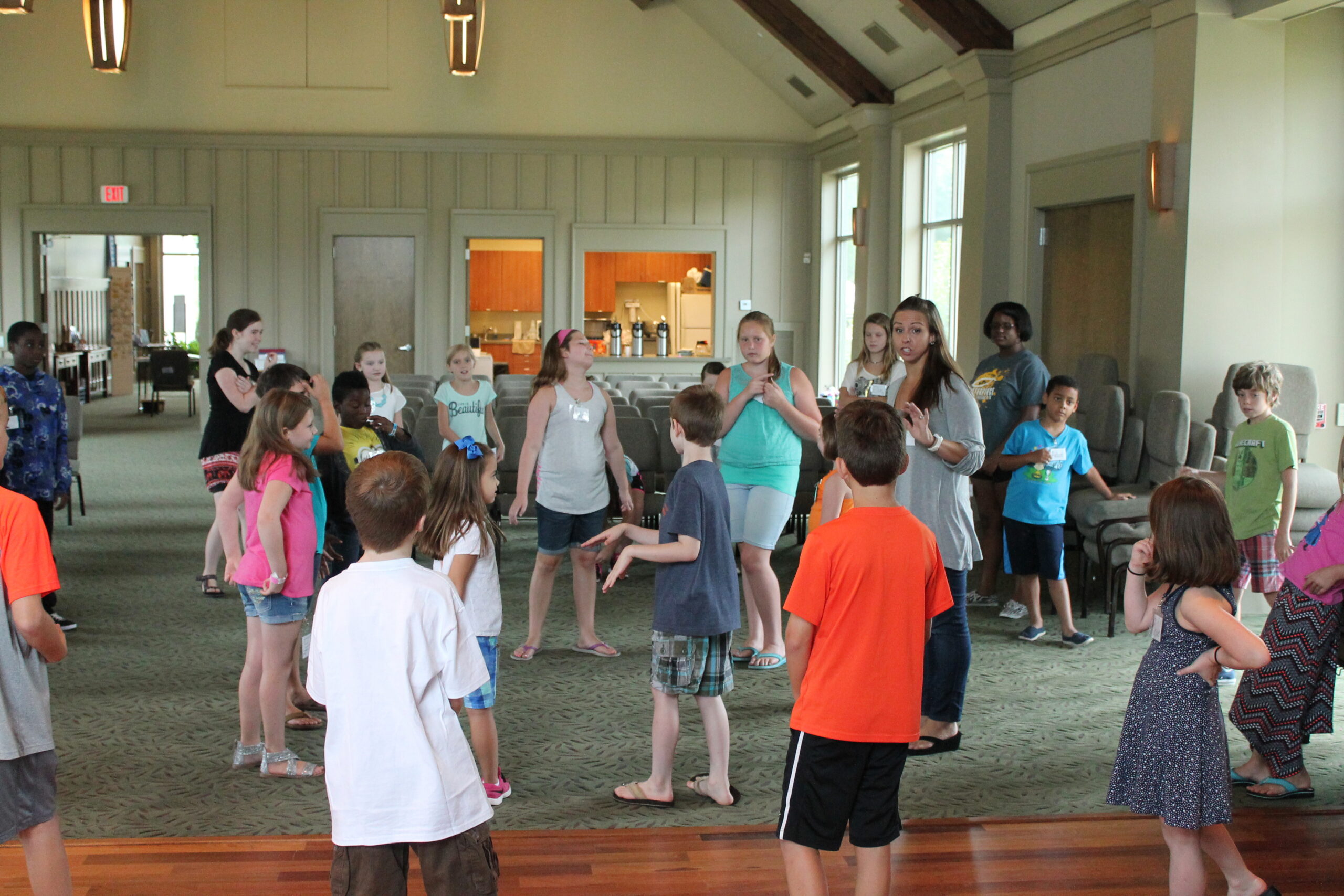 Children gathered in a room, engaging in an activity led by an adult.