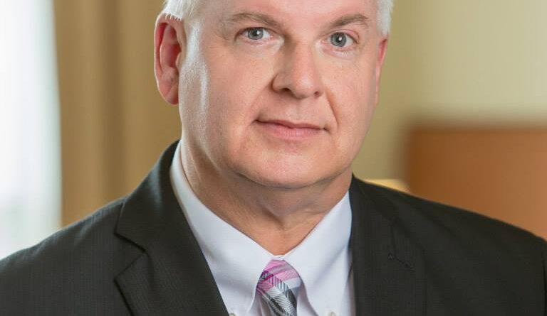 Man in suit with light-colored tie.